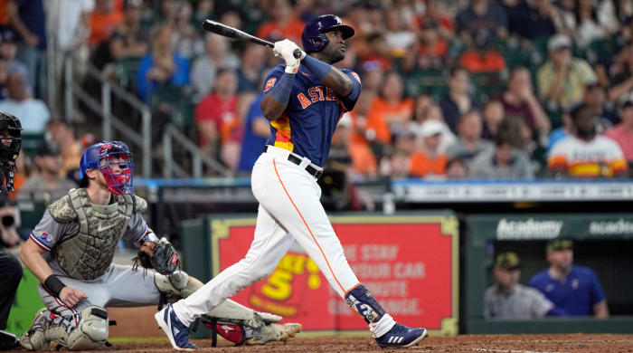 Houston Astros’ Yordan Alvarez, right, hits an RBI-double as Texas Rangers catcher Sam Huff watches during the fifth inning of a baseball game Sunday, May 22, 2022, in Houston.